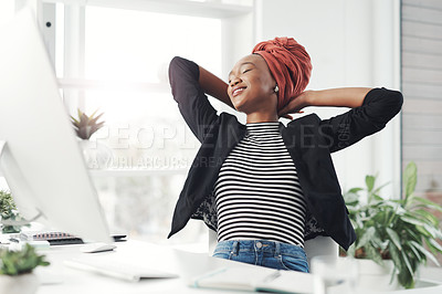 Buy stock photo Cropped shot of an attractive young businesswoman sitting at her desk with her hands behind her head
