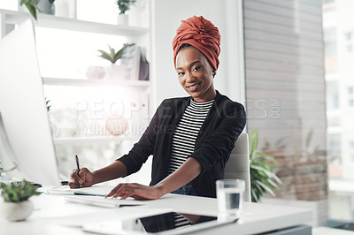 Buy stock photo Cropped portrait of an attractive young businesswoman taking notes while working at her desk in the office