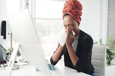 Buy stock photo Cropped shot of an attractive young businesswoman blowing her nose while working at her desk in the office