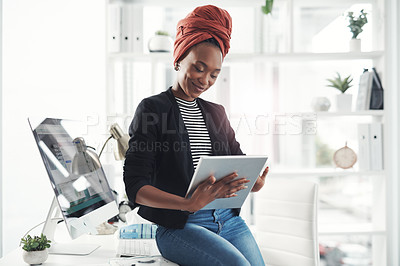 Buy stock photo Cropped shot of an attractive young businesswoman working on her digital tablet in the office