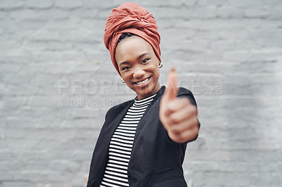 Buy stock photo Cropped portrait of an attractive young businesswoman giving you thumbs up against a grey brick wall outside