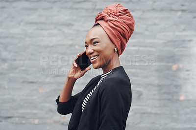 Buy stock photo Cropped shot of an attractive young businesswoman making a phonecall while posing against a grey brick wall outside