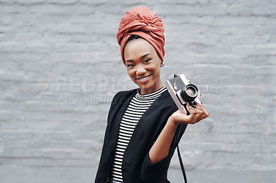 Buy stock photo Cropped portrait of an attractive young businesswoman posing with her camera against a grey brick wall outside
