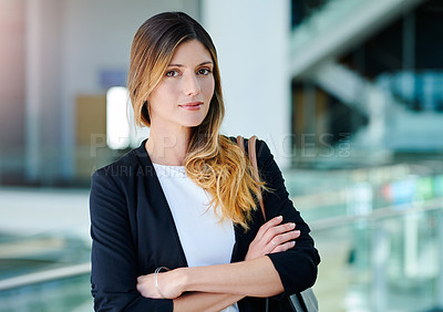 Buy stock photo Cropped portrait of an attractive young businesswoman standing with her arms crossed in an office