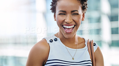 Buy stock photo Cropped portrait of an attractive young businesswoman laughing while standing in a modern office