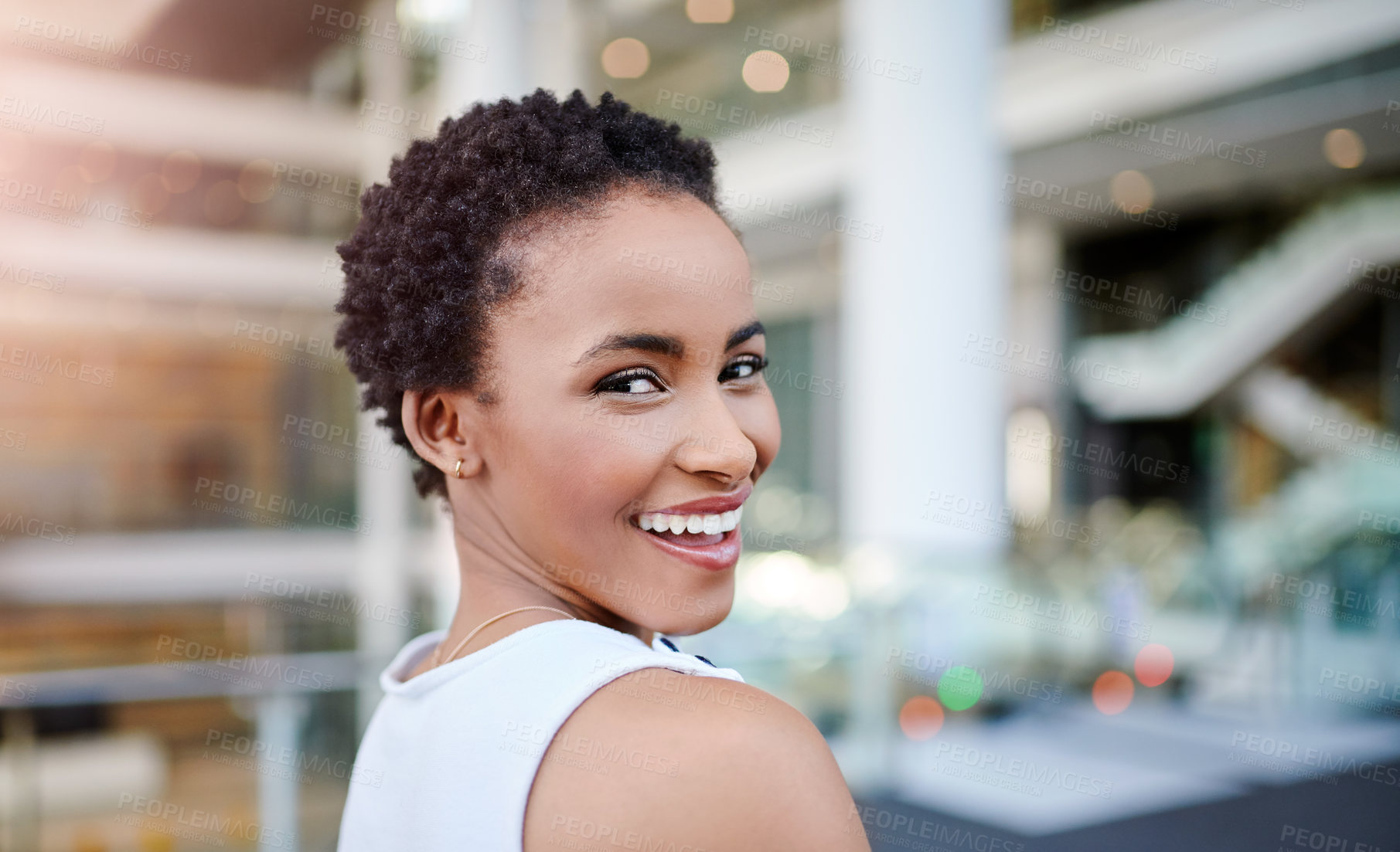 Buy stock photo Cropped portrait of an attractive young businesswoman smiling while standing in a modern workplace