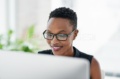 Buy stock photo Shot of a confident young businesswoman using a computer in a modern office