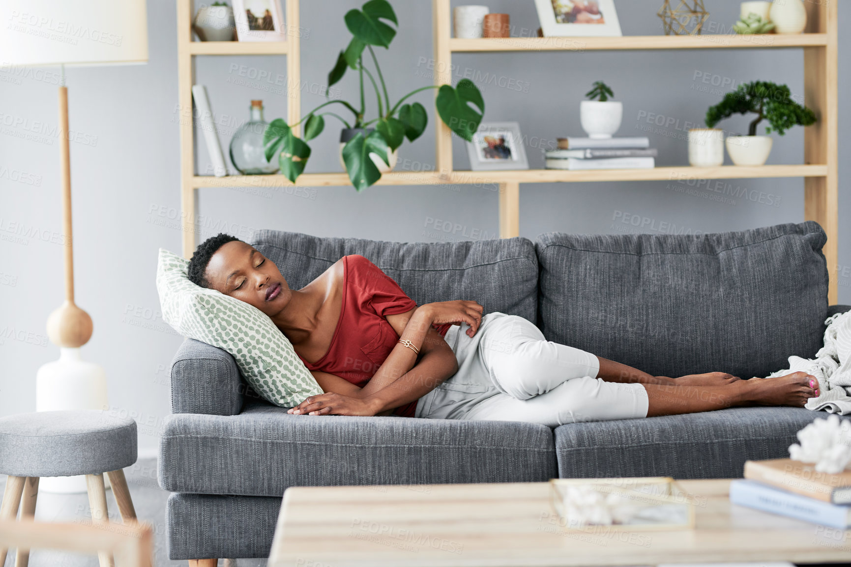 Buy stock photo Shot of a young woman having a nap on the sofa at home
