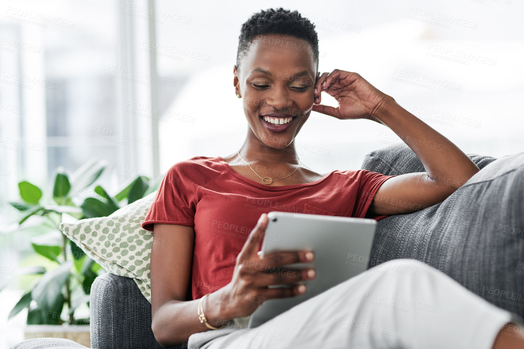 Buy stock photo Digital tablet, happy and black woman relax on a sofa for social media, reading and browsing blog in her home. Smile, online and African female person on couch with ebook, streaming or subscription 