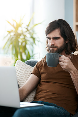 Buy stock photo Shot of a handsome young man relaxing the sofa in his living room