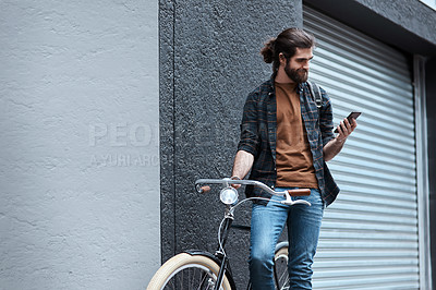 Buy stock photo Shot of a handsome young man travelling with his bicycle outdoors