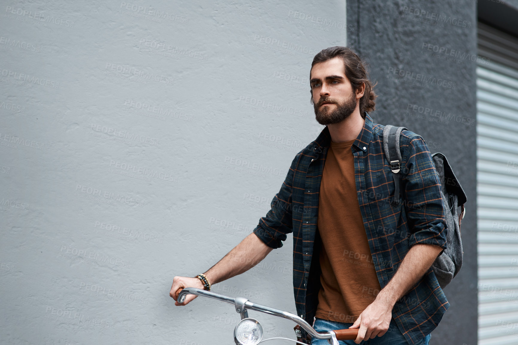 Buy stock photo Shot of a handsome young man travelling with his bicycle outdoors