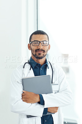 Buy stock photo Portrait of a young doctor holding a digital tablet in a modern hospital