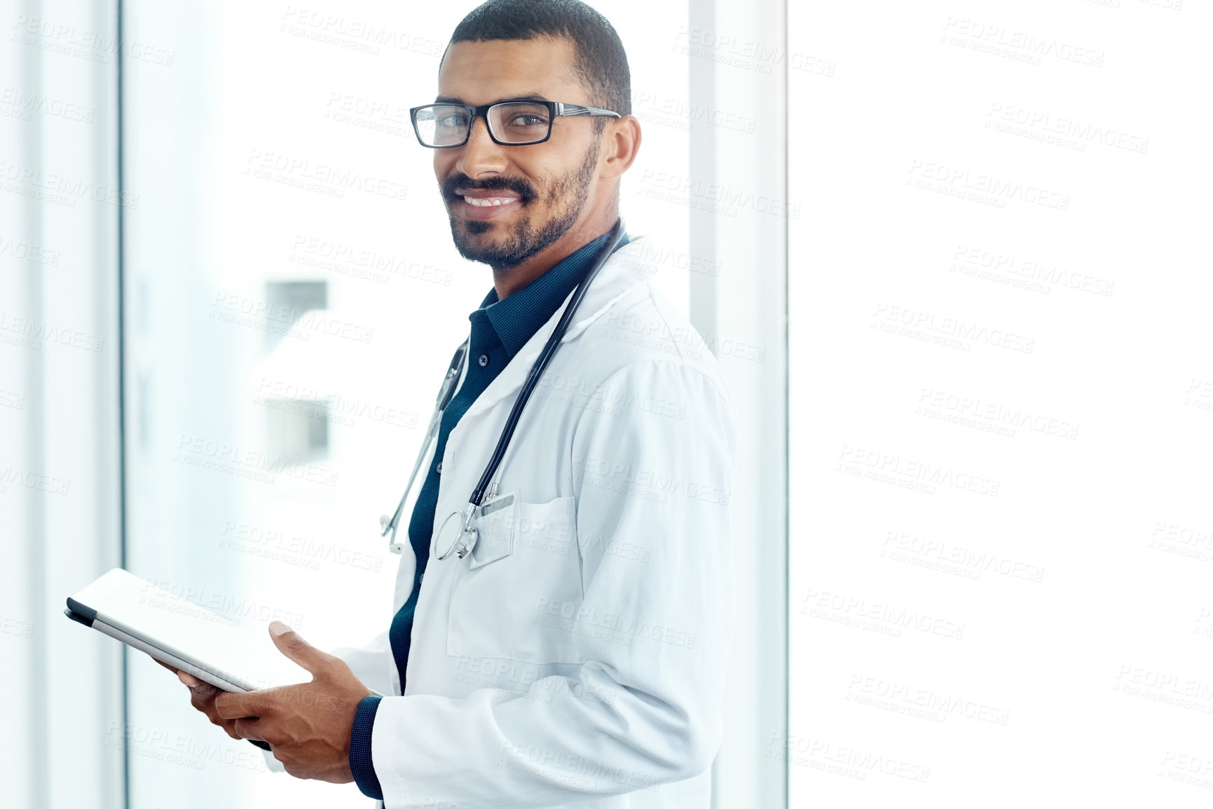 Buy stock photo Portrait of a young doctor using a digital tablet in a modern hospital