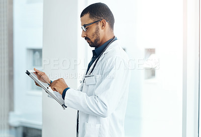 Buy stock photo Shot of a young doctor using a digital tablet in a modern hospital