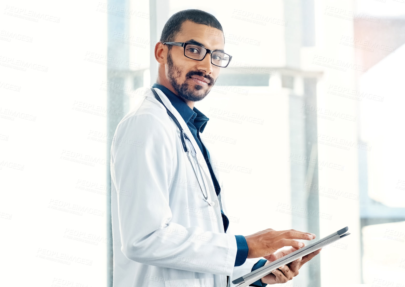 Buy stock photo Portrait of a young doctor using a digital tablet in a modern hospital