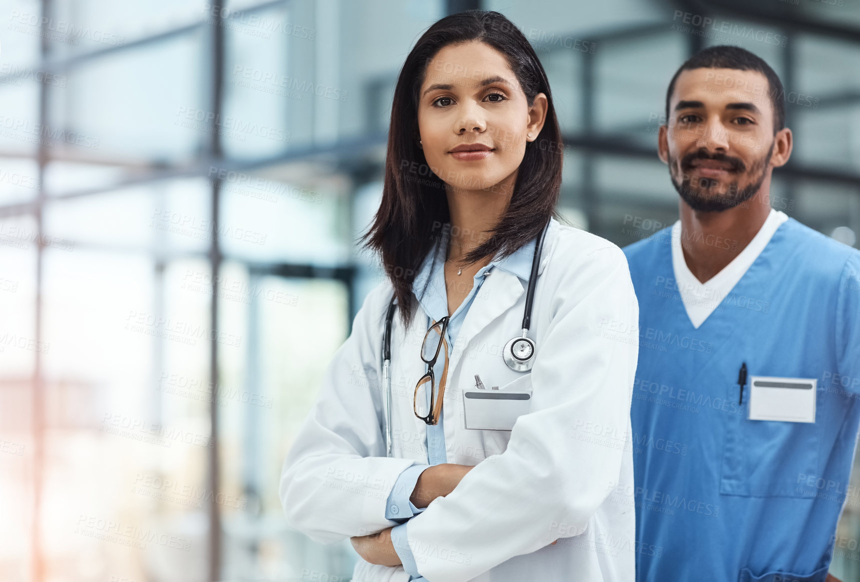 Buy stock photo Portrait of two confident young doctors working in a modern hospital
