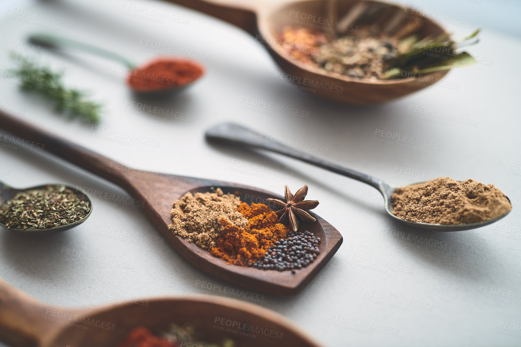 Buy stock photo Closeup, spoon or spices in studio for seasoning, recipe or healthy cooking in Indian cuisine. Utensils, powder or ingredients on white background for spicy meal, flavor preparation or culinary skill