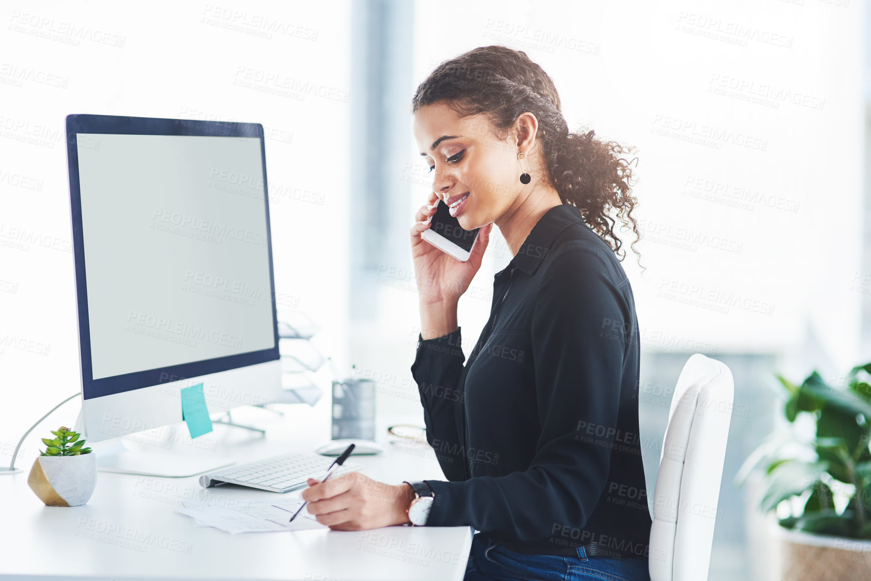 Buy stock photo Shot of a young businesswoman talking on a cellphone while working in an office