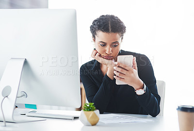 Buy stock photo Shot of a young businessman looking bored while checking her cellphone in an office