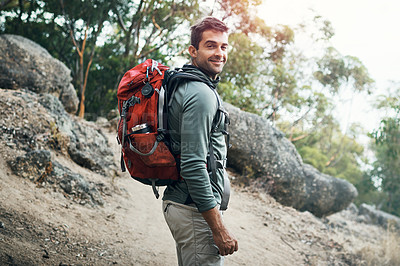 Buy stock photo Portrait of a cheerful young man wearing a backpack and ready to hike up a mountain