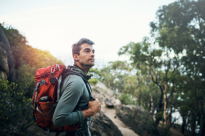 Buy stock photo Cropped shot of a cheerful young man wearing a backpack and ready to hike up a mountain