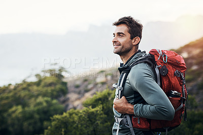 Buy stock photo Cropped shot of a cheerful young man looking into the  distance while going for a hike up a mountain
