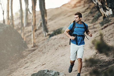 Buy stock photo Cropped shot of a cheerful young man looking into the  distance while going for a hike up a mountain