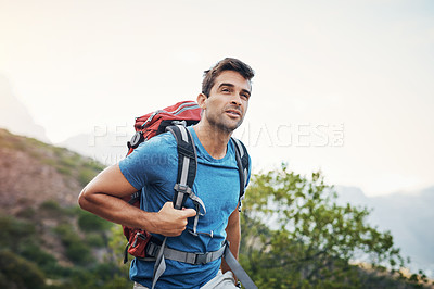 Buy stock photo Cropped shot of a carefree young man looking into the  distance while going for a hike up a mountain