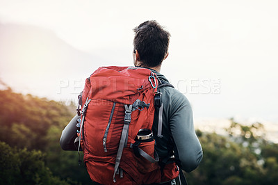Buy stock photo Cropped  shot of a cheerful young man looking into the  distance while going for a hike up a mountain