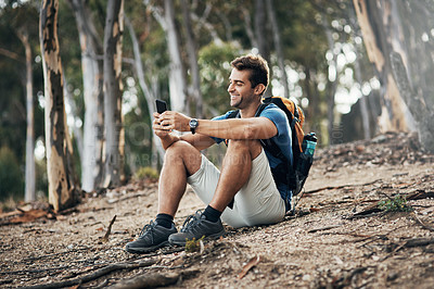 Buy stock photo Cropped shot of a carefree young man taking a quick break from hiking up a mountain during the day