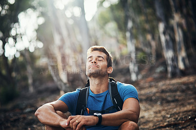 Buy stock photo Cropped shot of a carefree young man taking a quick break from hiking up a mountain during the day