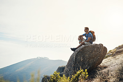 Buy stock photo Cropped shot of a carefree young man sitting on top of a mountain after a day of hiking
