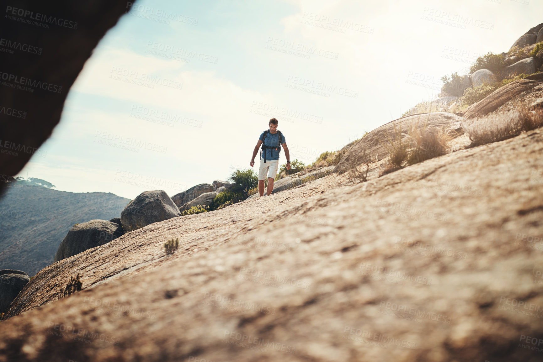 Buy stock photo Cropped shot of a carefree young man going for a hike up a mountain outside during the day
