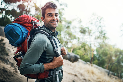 Buy stock photo Portrait of a carefree young man going for a hike up a mountain outside during the day