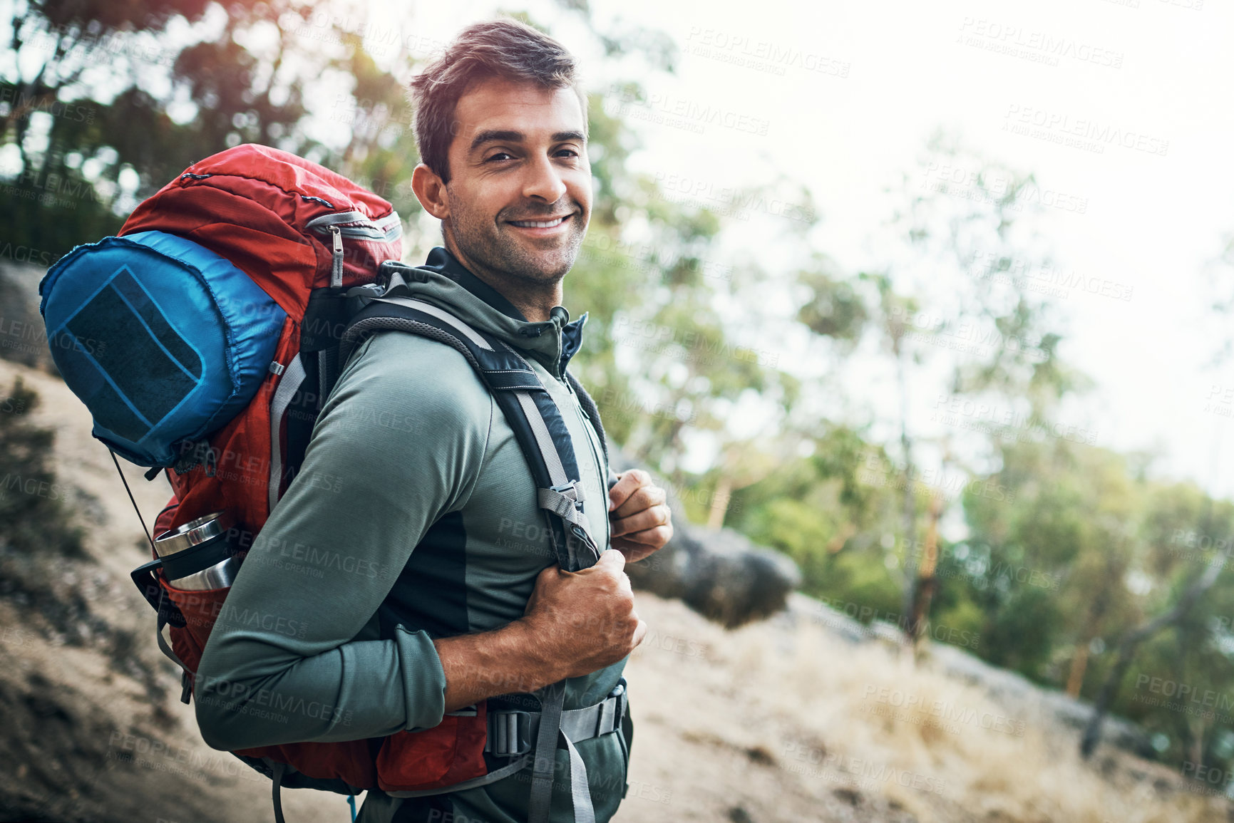 Buy stock photo Hiking, portrait or fitness man with backpack in forest for wellness, peace and morning cardio in nature. Sport, smile and happy athlete explorer in park for exercise, training or travel adventure