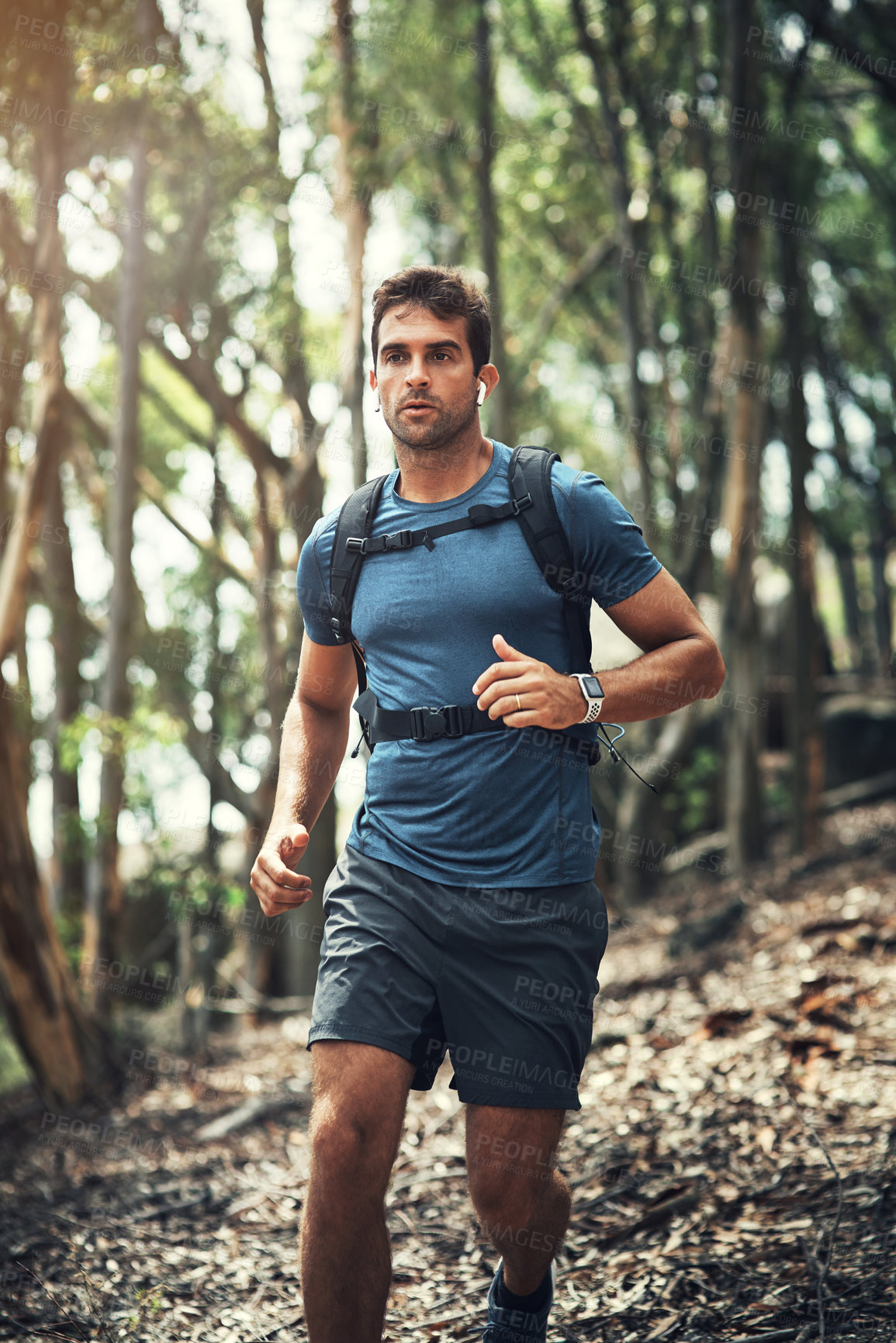 Buy stock photo Cropped shot of a handsome young man running during his hike in the mountains
