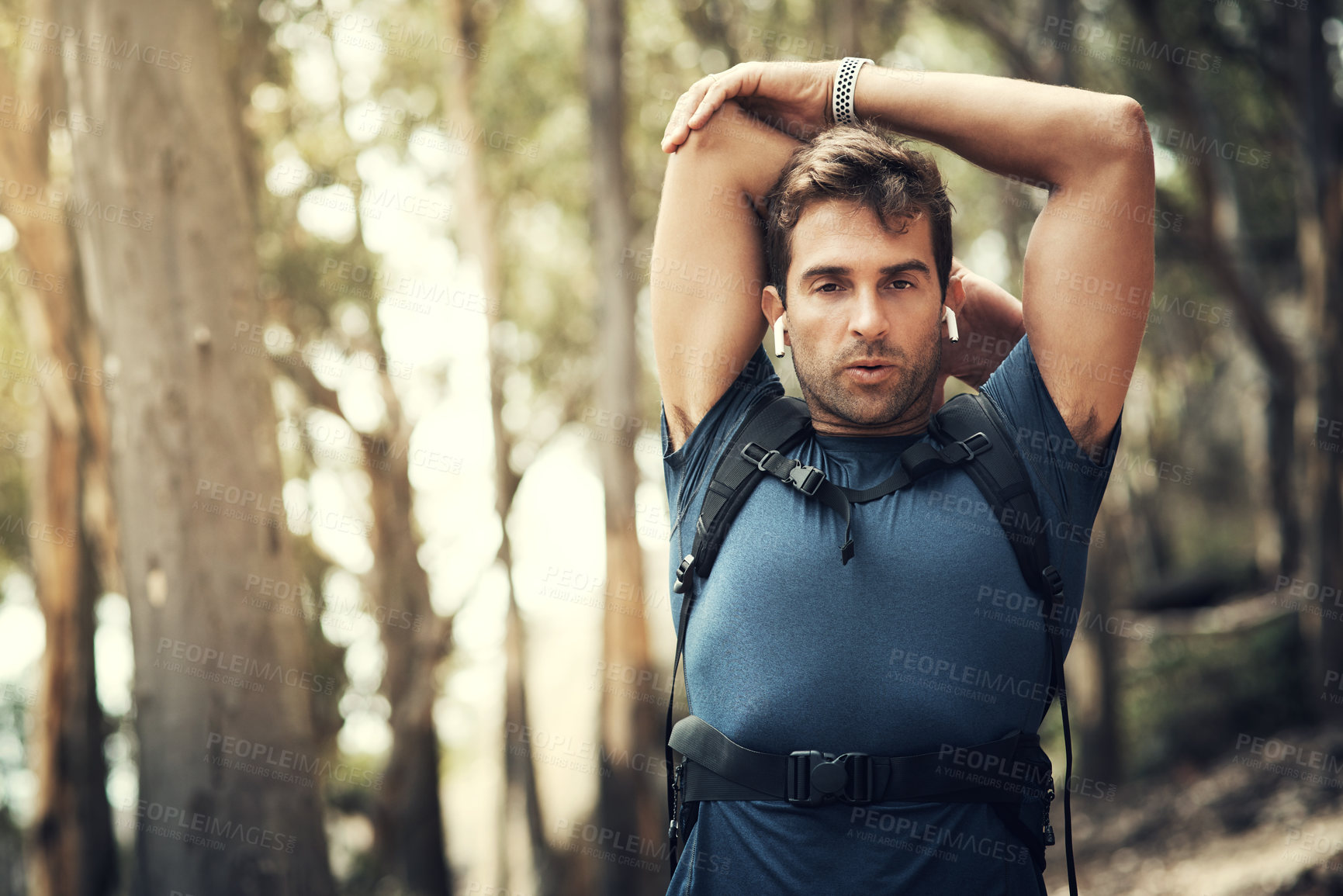 Buy stock photo Cropped portrait of a handsome young man stretching before heading off on his hike in the mountains