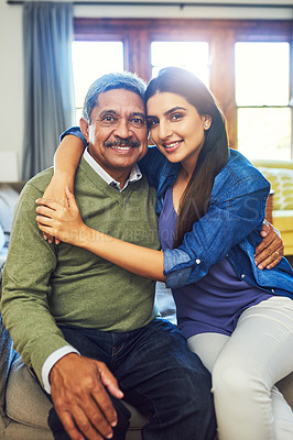 Buy stock photo Portrait of a cheerful senior man posing with his daughter while relaxing on a couch at home