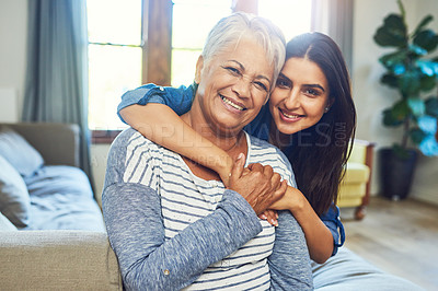 Buy stock photo Portrait of a beautiful senior woman posing with her daughter while relaxing on a sofa at home