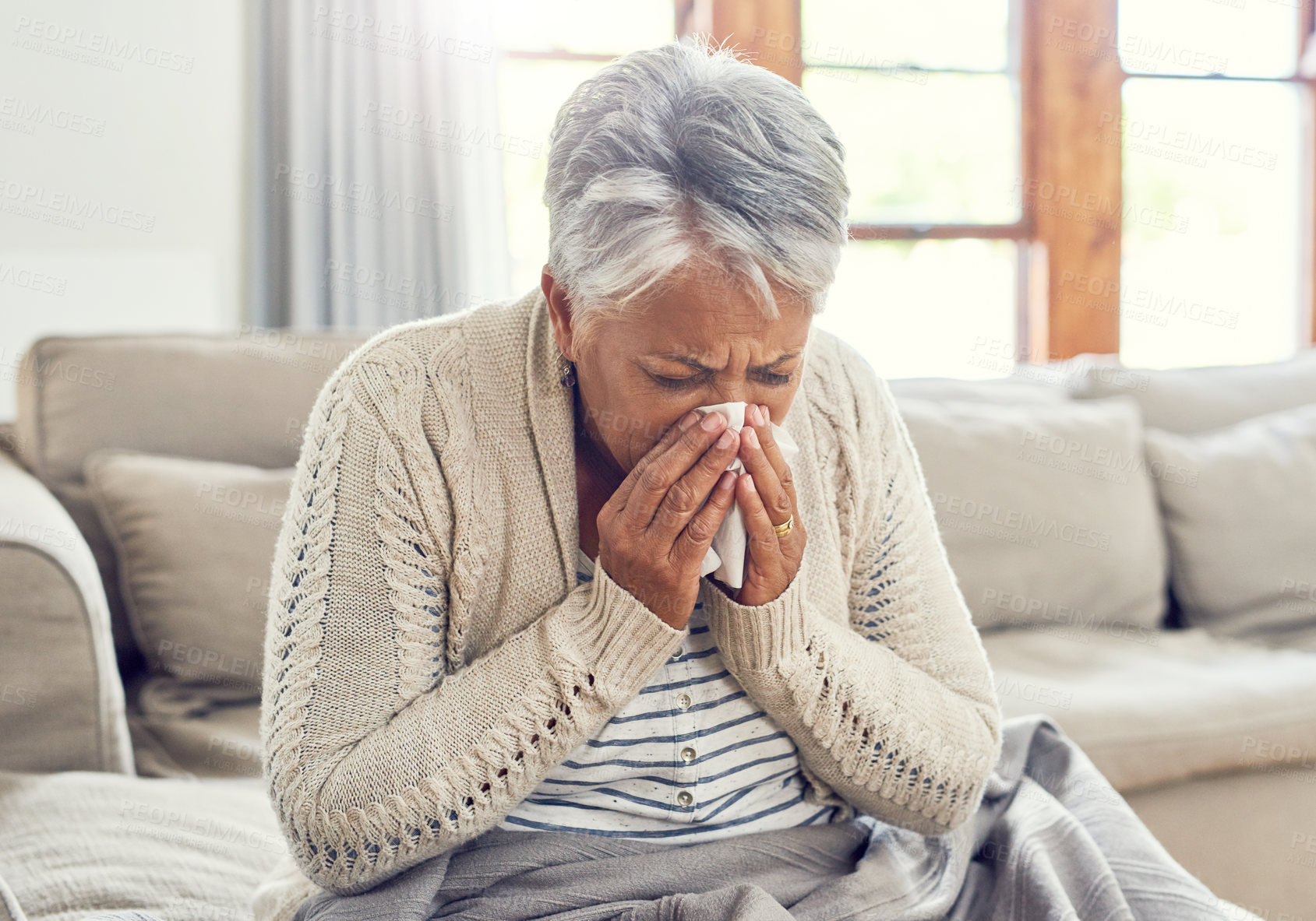 Buy stock photo Senior woman, sick and blowing nose at home from virus, allergy and illness on couch. Tired, tissue and elderly female person in a house lounge with sneeze from covid and flu on a sofa with allergies