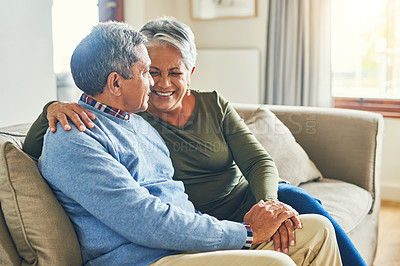 Buy stock photo Shot of an affectionate senior couple relaxing on a sofa together at home