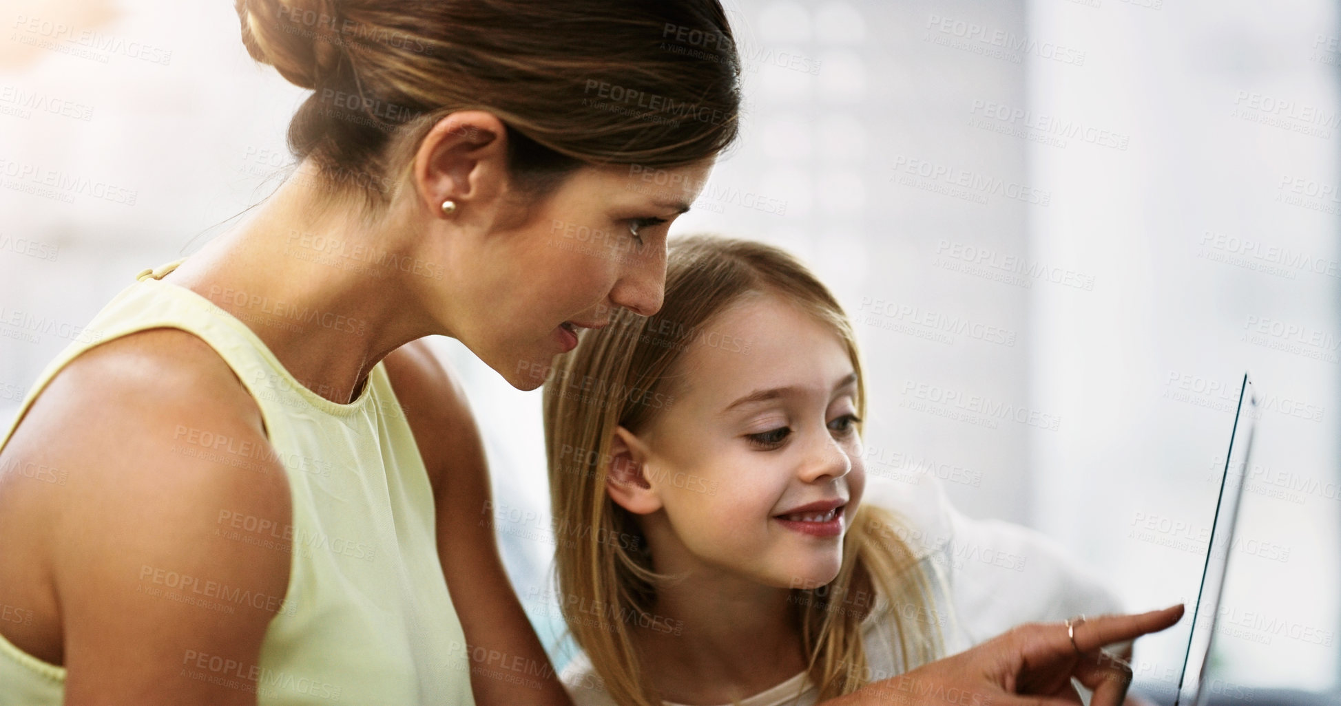 Buy stock photo Shot of a beautiful young mother and her daughter using a digital tablet together at home