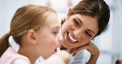 Buy stock photo Shot of a beautiful young mother watching her daughter brush her teeth in the bathroom at home