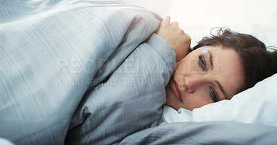 Buy stock photo Cropped shot of an attractive young woman feeling depressed while lying in bed at home