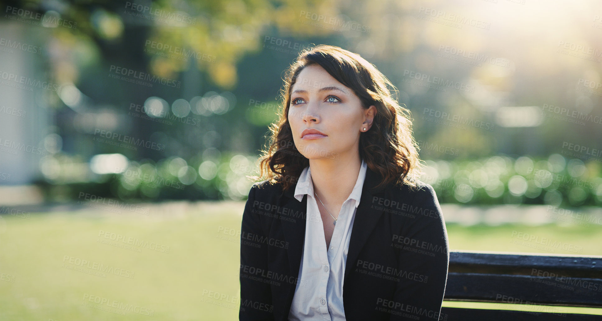 Buy stock photo Cropped shot of an attractive young businesswoman feeling depressed while sitting in a public park
