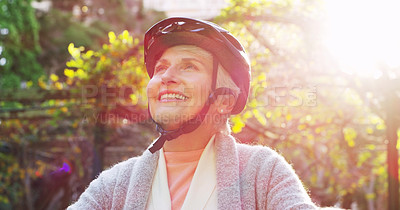 Buy stock photo Cycling, face and helmet with senior woman outdoor in garden for retirement recreation or wellness. Exercise, smile and thinking with happy cyclist at park in summer for active hobby or leisure