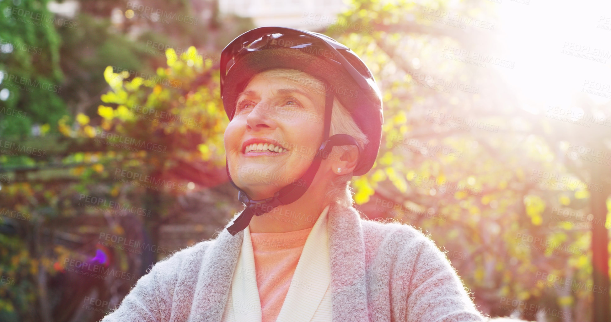 Buy stock photo Cropped shot of a cheerful elderly woman riding a bicycle outside in a park