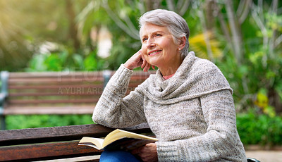 Buy stock photo Cropped shot of a cheerful elderly woman reading a book by herself outside in a park