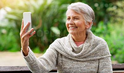 Buy stock photo Senior woman, phone and selfie in park for social media post, travel and relax on garden bench. Female person, smile and camera app for picture in outdoor nature, photo and holiday in retirement